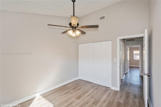 unfurnished bedroom featuring ceiling fan, light hardwood / wood-style floors, and a closet