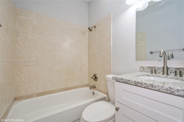 full bathroom with vanity, tiled shower / bath combo, and toilet