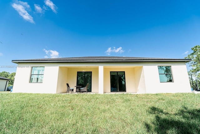 back of house with a lawn