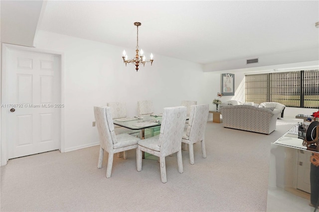 dining space with a chandelier and light carpet