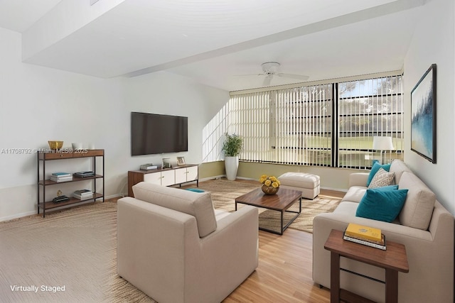 living room with ceiling fan, plenty of natural light, and light wood-type flooring