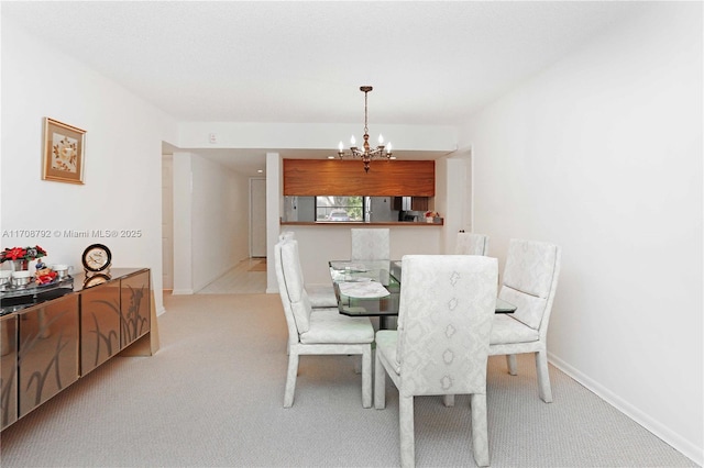 dining space featuring light colored carpet and a chandelier