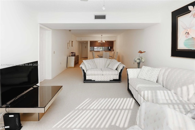 carpeted living room with a notable chandelier