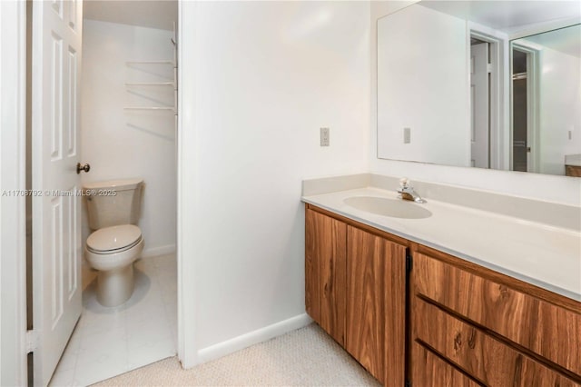 bathroom with tile patterned flooring, vanity, and toilet