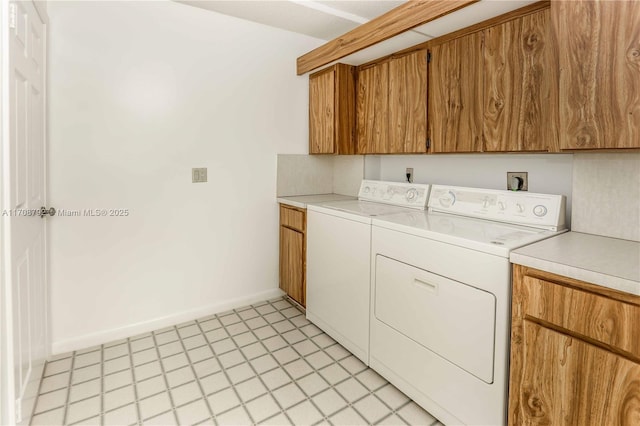 clothes washing area featuring cabinets and washer and dryer