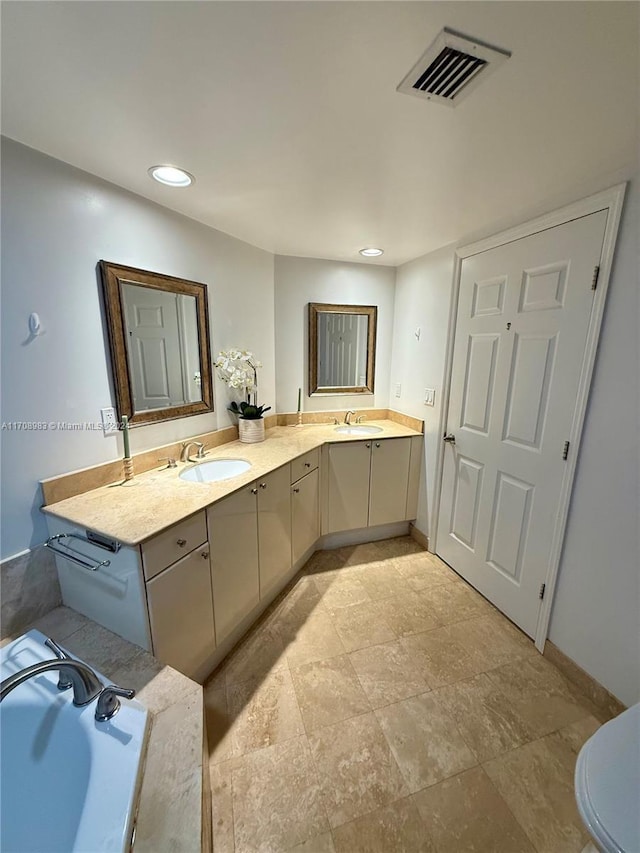 bathroom featuring vanity, toilet, and a washtub