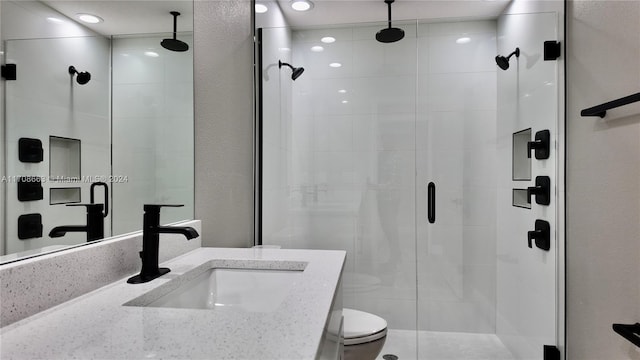 bathroom featuring toilet, vanity, and walk in shower