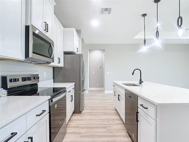 kitchen featuring hanging light fixtures, white cabinetry, sink, and stainless steel appliances