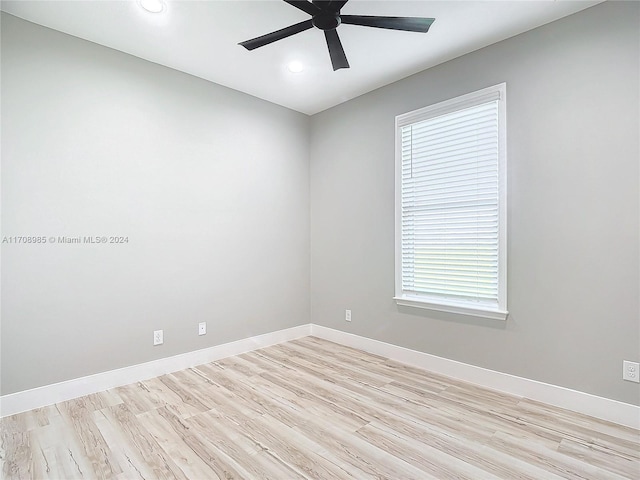 spare room with ceiling fan, a wealth of natural light, and light hardwood / wood-style flooring