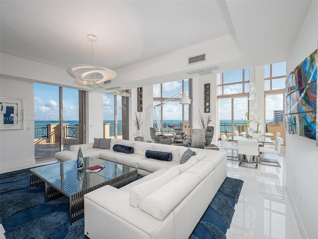 living room with a water view and an inviting chandelier