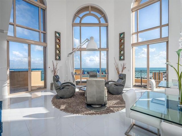 living room featuring a towering ceiling and a water view