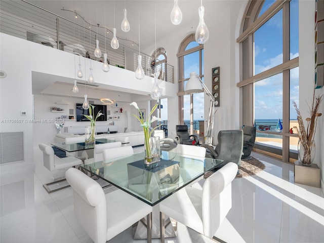 dining room with light tile patterned floors, a high ceiling, and a wealth of natural light