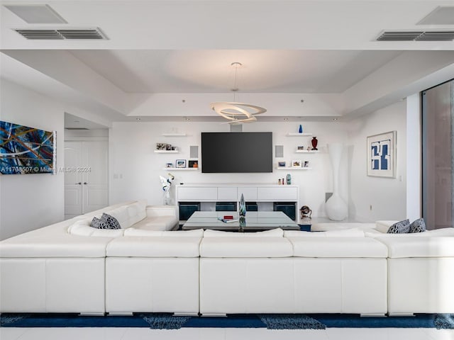 tiled living room with a tray ceiling