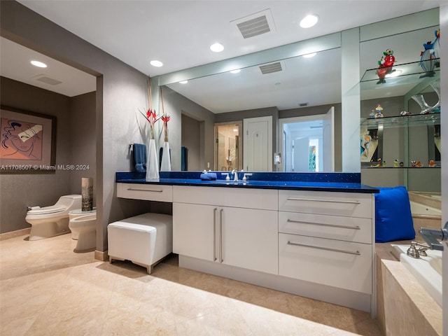 bathroom with vanity, a bathtub, toilet, and a bidet