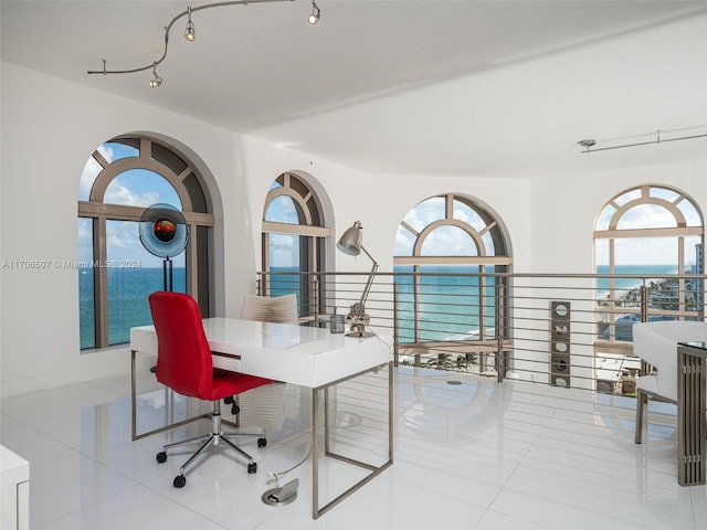 office with light tile patterned floors, a water view, and a wealth of natural light