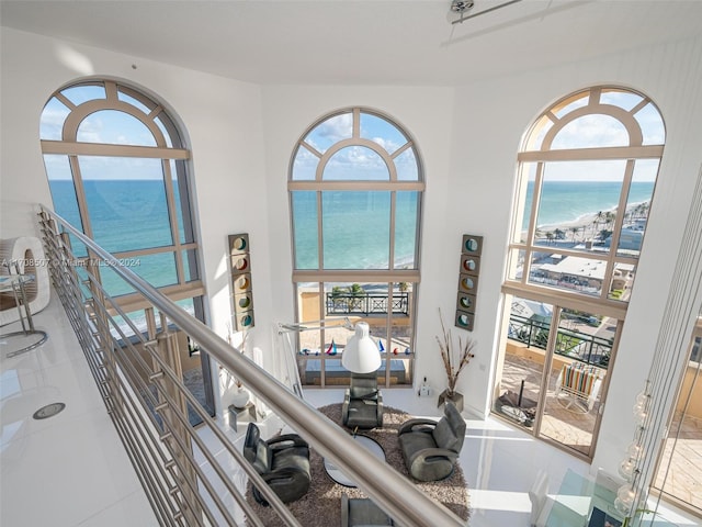 stairway with a wealth of natural light, tile patterned flooring, and a water view