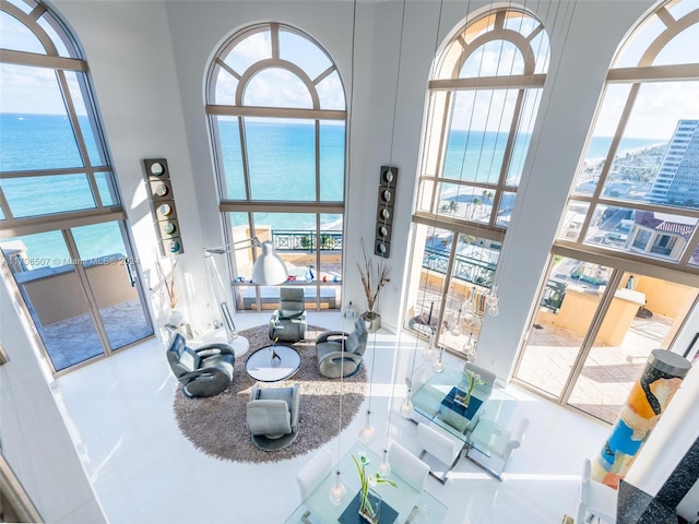 interior space with tile patterned flooring, a water view, and a healthy amount of sunlight