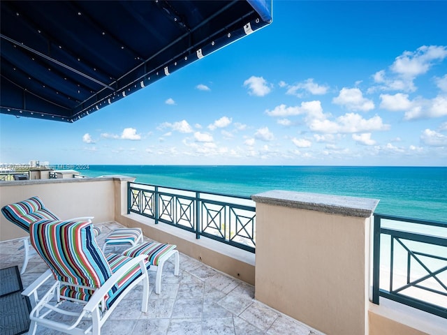 balcony featuring a water view and a view of the beach