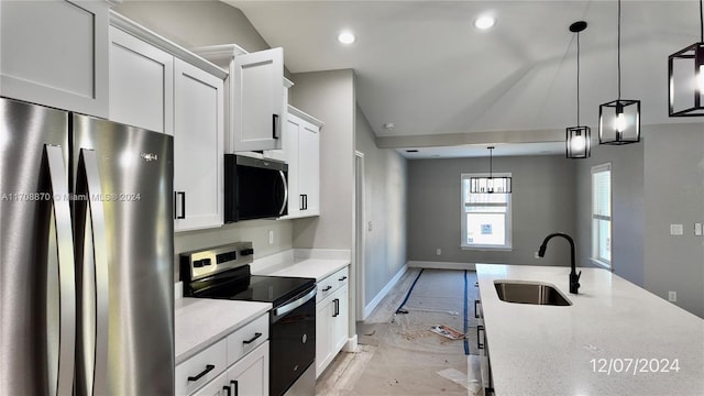 kitchen featuring white cabinets, decorative light fixtures, sink, and appliances with stainless steel finishes