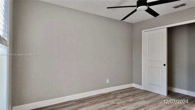 unfurnished bedroom with ceiling fan, a closet, and light wood-type flooring