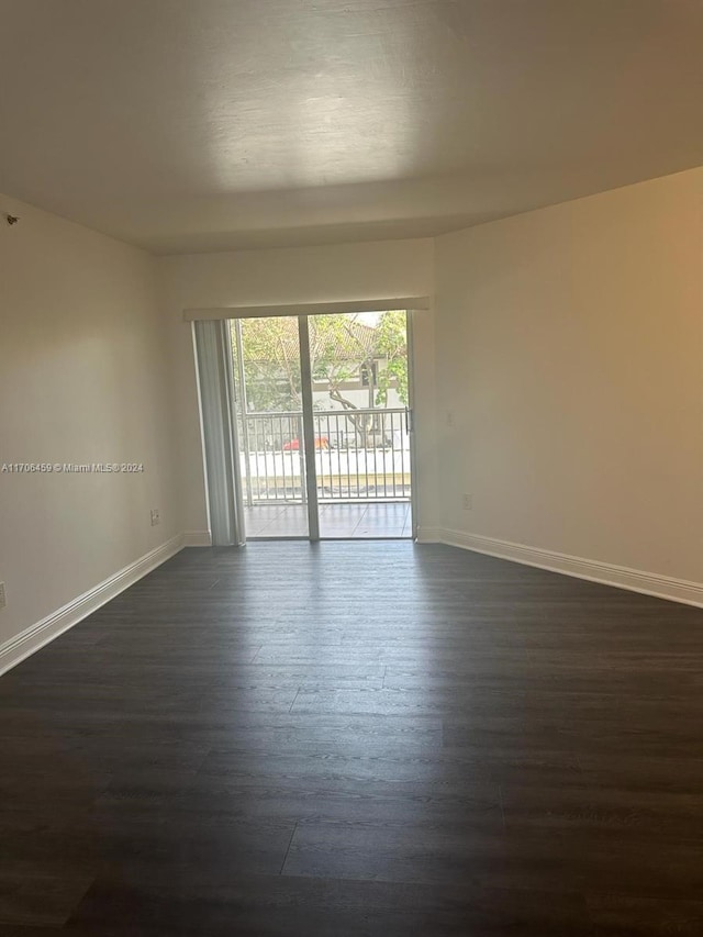 unfurnished room with dark hardwood / wood-style flooring