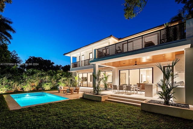 rear view of house with ceiling fan, a balcony, a patio, and an outdoor living space