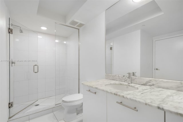 bathroom featuring tile patterned floors, vanity, toilet, and an enclosed shower