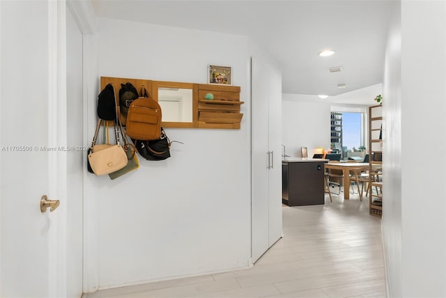 corridor with light hardwood / wood-style floors