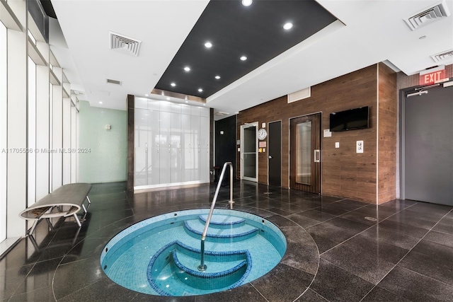 view of pool featuring elevator and an indoor hot tub