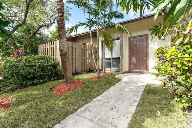 view of exterior entry with a lawn