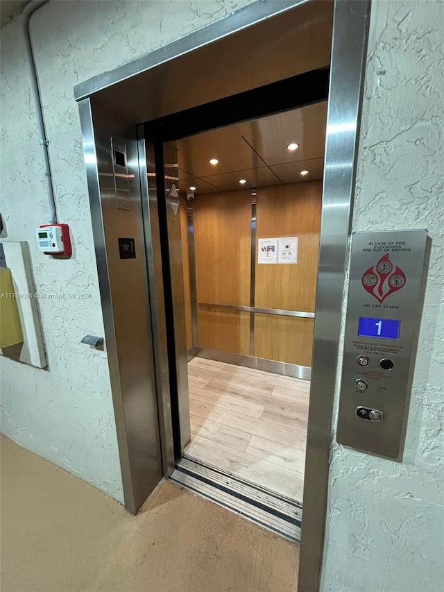 interior details featuring wood-type flooring and elevator