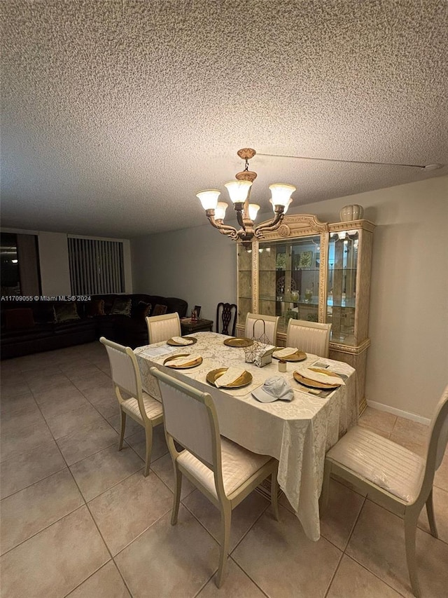 dining space with tile patterned floors, a chandelier, and a textured ceiling