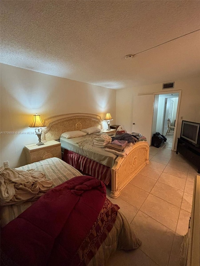 bedroom with light tile patterned floors and a textured ceiling