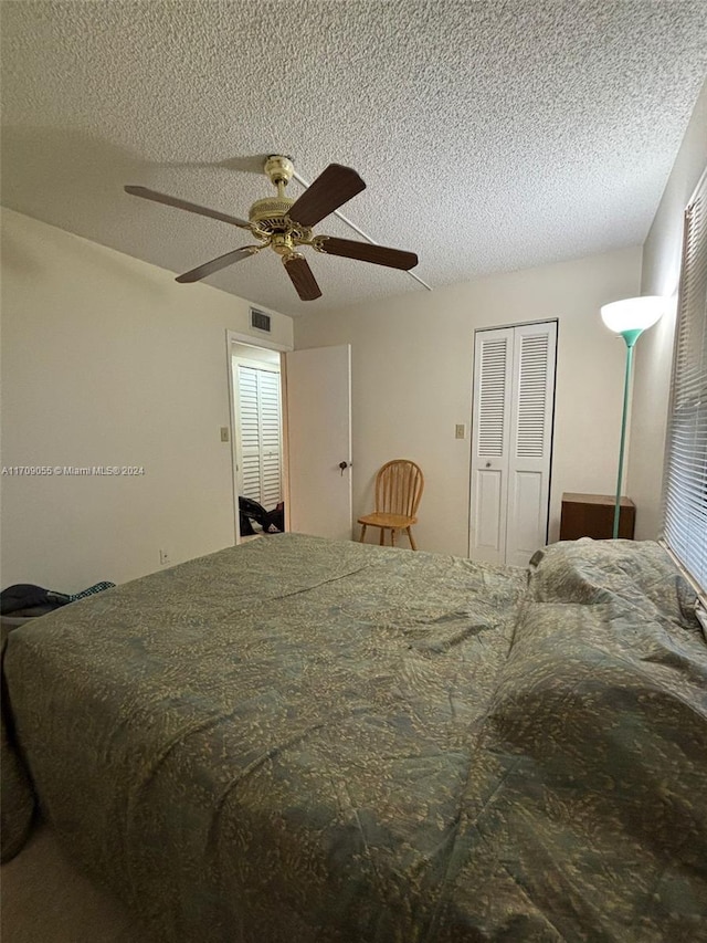 bedroom featuring ceiling fan, a closet, and a textured ceiling