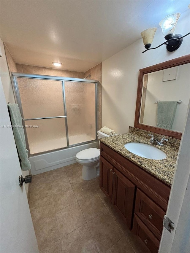 full bathroom with tile patterned floors, vanity, toilet, and enclosed tub / shower combo