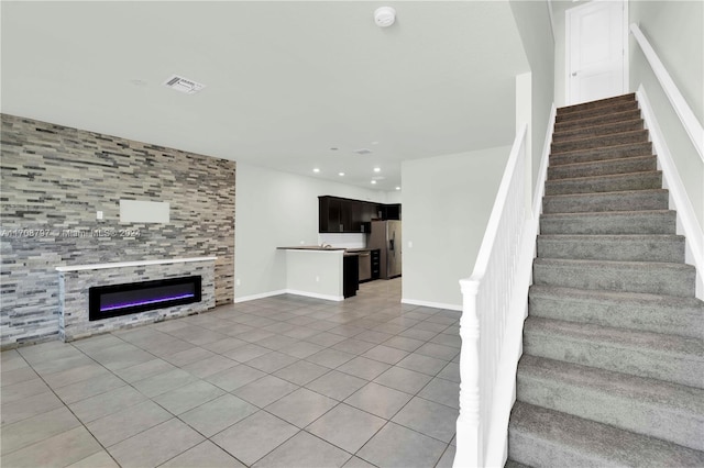 stairs featuring tile patterned floors and a fireplace