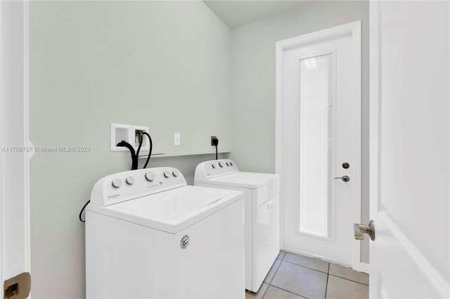 laundry room with light tile patterned floors and washer and clothes dryer