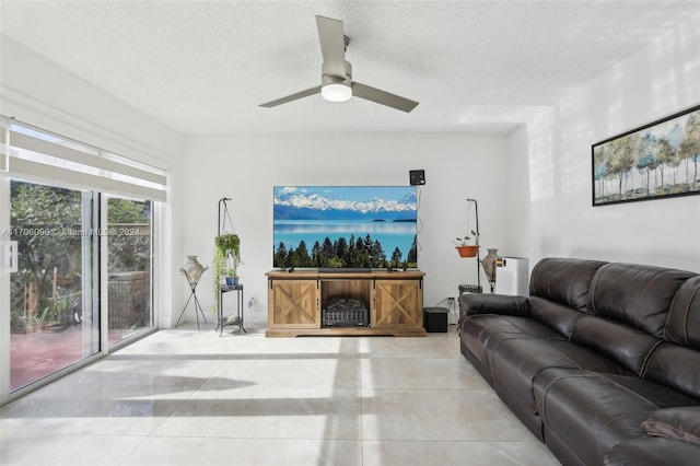 living room featuring ceiling fan and a textured ceiling