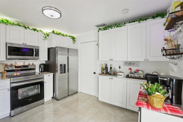 10949 Mainsail Dr, Cooper City, FL 33026 - kitchen with appliances with stainless steel finishes, white cabinetry, light countertops, and light tile patterned floors