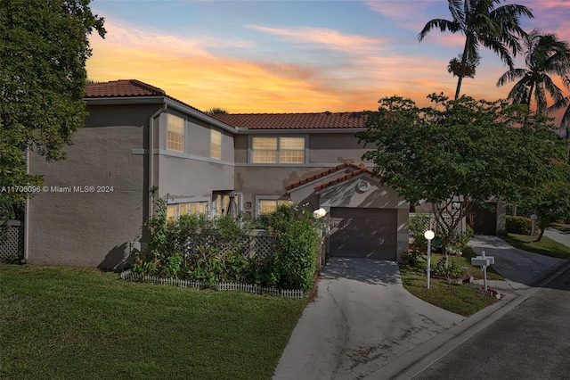 mediterranean / spanish-style home featuring a yard and a garage