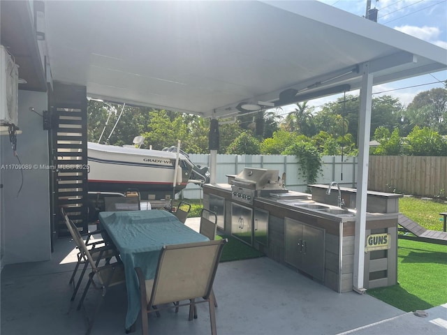 view of patio with an outdoor kitchen, sink, and grilling area