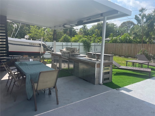 view of patio with an outdoor kitchen, area for grilling, and sink