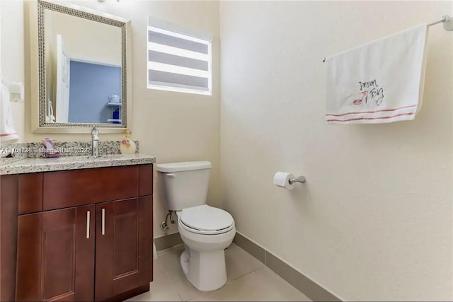 bathroom featuring tile patterned flooring, vanity, and toilet