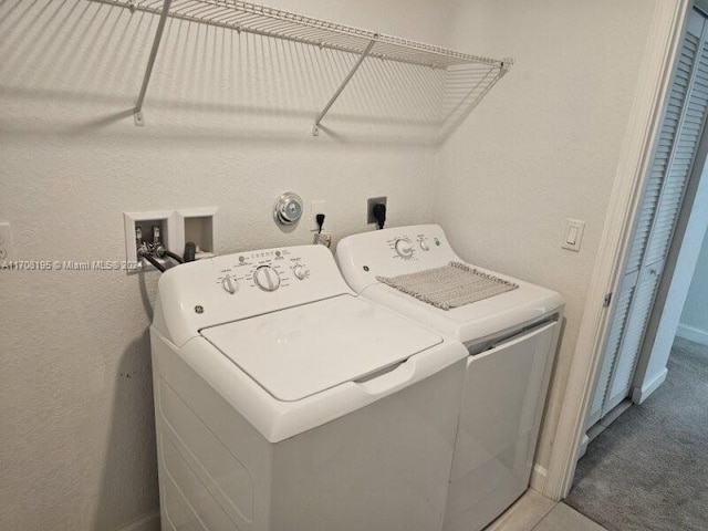 clothes washing area with washing machine and dryer and carpet