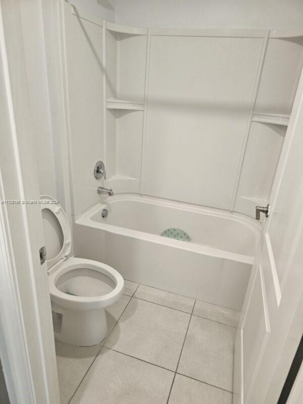 bathroom featuring toilet, shower / bath combination, and tile patterned floors