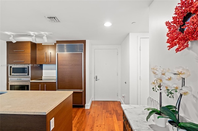 kitchen with light wood-type flooring and appliances with stainless steel finishes