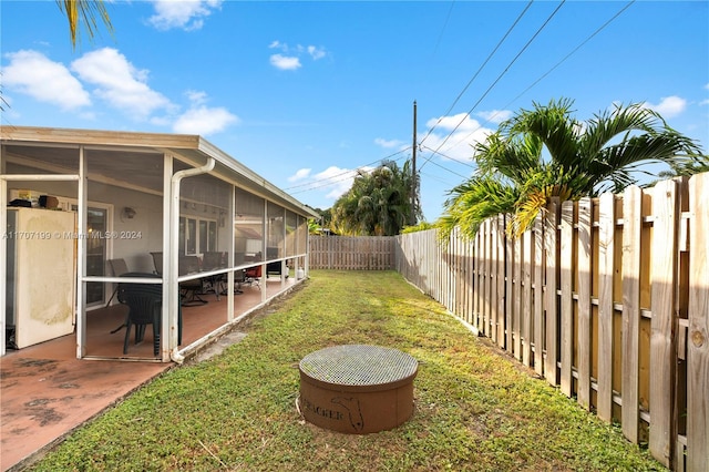 view of yard featuring a sunroom and a patio