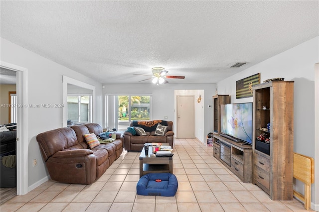 living room with light tile patterned floors, a textured ceiling, and ceiling fan