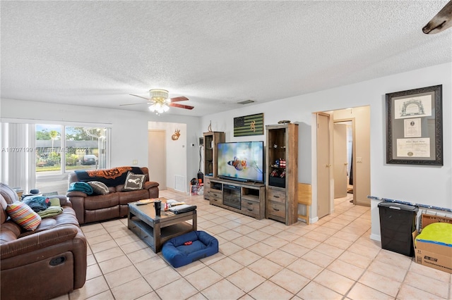 tiled living room with a textured ceiling and ceiling fan