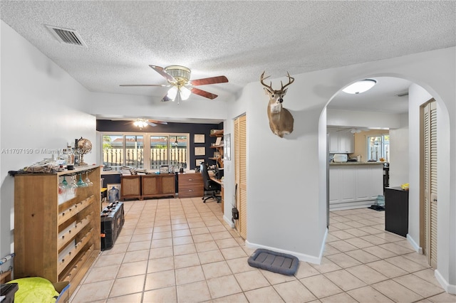 kitchen featuring ceiling fan, light tile patterned floors, and a textured ceiling